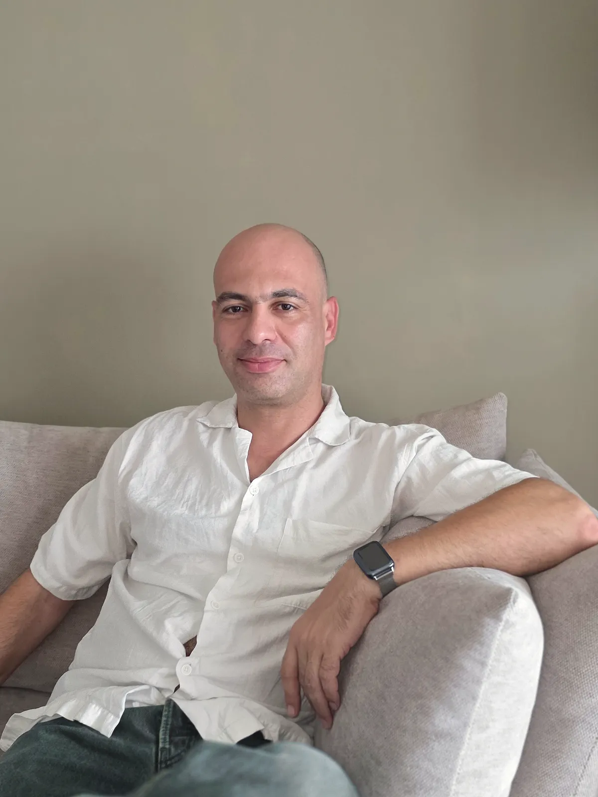 Vitaly Gurvich seated in a living room, looking at the camera